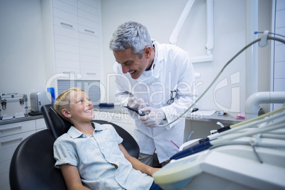 Dentist examining a young patient with tools