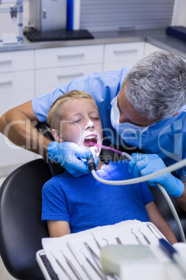 Dentist examining a young patient with tools