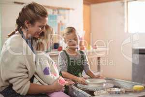 Female potter assisting girls