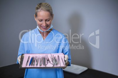 Dental assistant holding tray with equipment in dental clinic