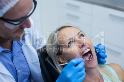 Dentist examining a woman with tools