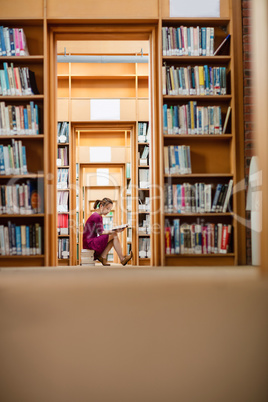 Young woman reading book in library