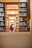 Young woman reading book in library