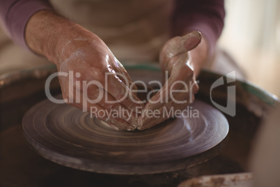 Male potter making bowl