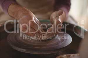 Male potter making bowl