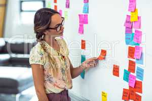 Woman putting sticky notes on whiteboard