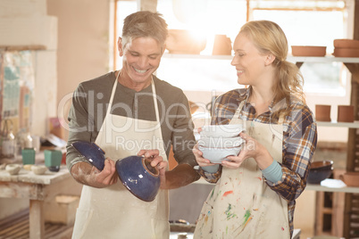 Smiling potters checking pots