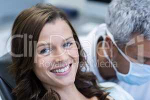 Smiling patient sitting on dentist chair