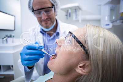 Dentist examining a woman with tools