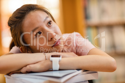 Thoughtful young woman leaning on book