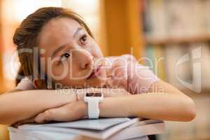 Thoughtful young woman leaning on book