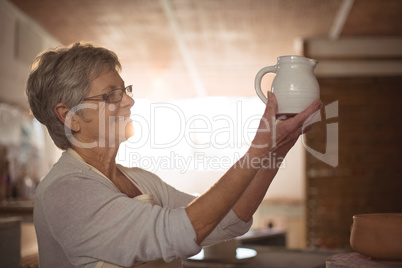 Female potter checking jug