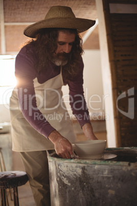 Male potter making bowl