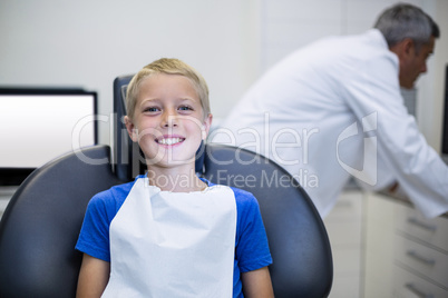 Smiling young patient sitting on dentist chair