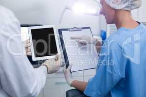 Dentist and dental assistant working on digital tablet