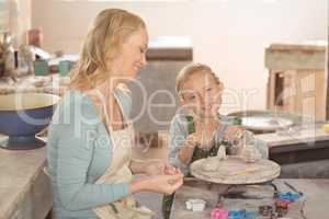 Female potter and girl working in workshop