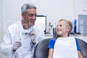 Smiling dentist talking to young patient