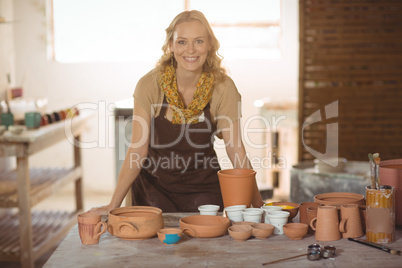 Beautiful female potter leaning on worktop