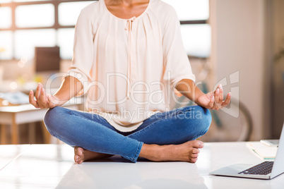 Female business executive performing yoga