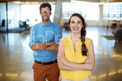 Business executive and co-worker standing with arms crossed