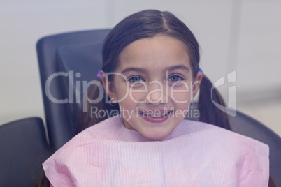 Smiling young patient sitting on dentists chair