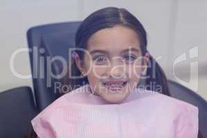 Smiling young patient sitting on dentists chair