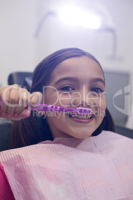 Young patient brushing her teeth