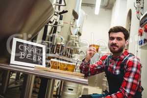 manufacturer holding beer glass in brewery