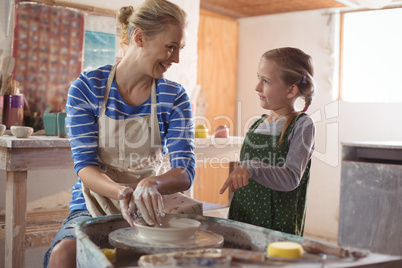 Female potter assisting girl