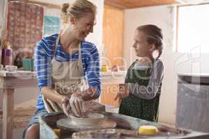 Female potter assisting girl