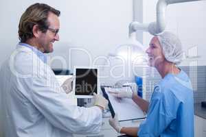Dentist and dental assistant working on digital tablet
