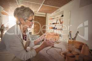 Female potter checking bowl