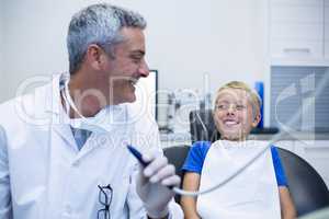 Smiling dentist talking to young patient