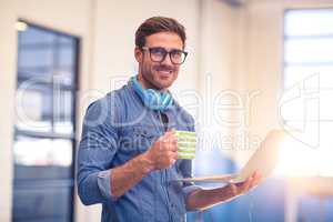 Business executive having coffee and holding a laptop