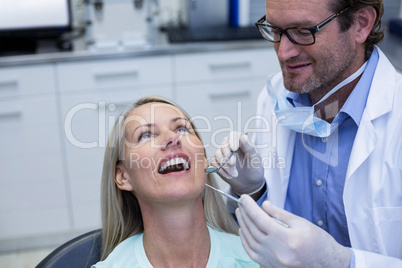 Dentist examining a woman with tools