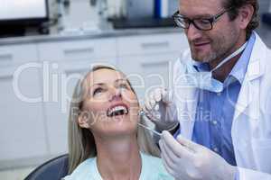 Dentist examining a woman with tools