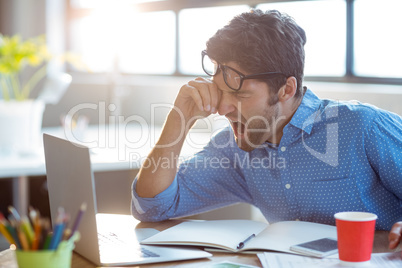 Male business executive yawning