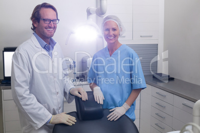 Smiling dentist and dental assistant standing together in dental