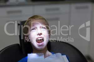 Young patient sitting on dentist chair with open mouth