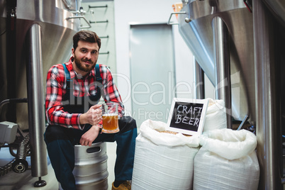 Manufacturer holding beer glass at brewery