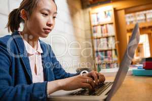 Young woman using laptop in library