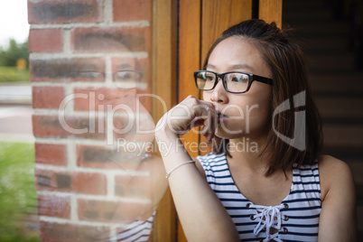 Thoughtful woman sitting on windowsill