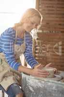 Beautiful female potter making pot