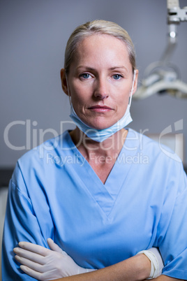 Dental assistant standing with arm crossed in clinic