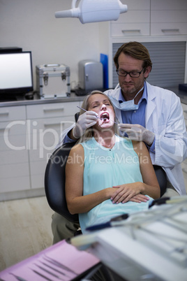 Dentist examining a woman with tools