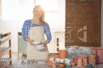 Beautiful female potter holding bowl
