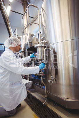 Manufacturer working at storage tanks in brewery