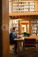 Young woman using laptop in library