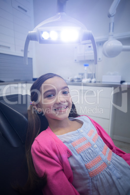 Smiling young patient sitting on dentists chair