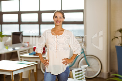 Business executive standing with hand on hip in office